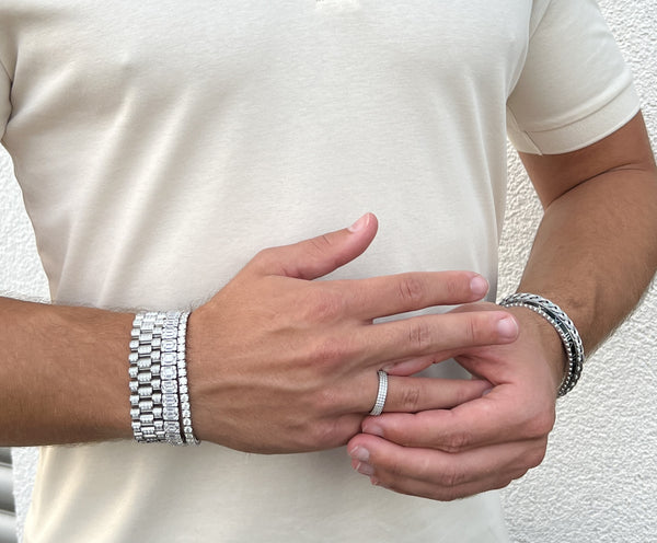 Men with white polo shirt wearing iced out diamond bracelets and Roman Speed bracelet